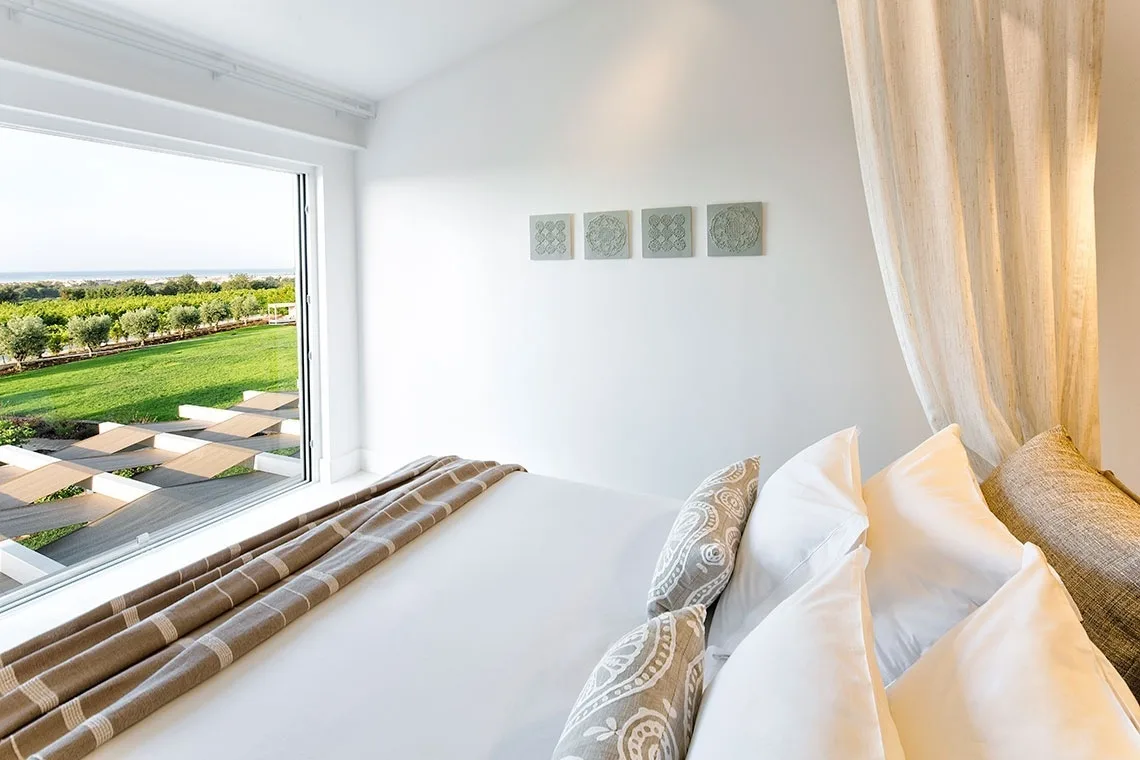 Guest room with a canopy bed, artwork and wood details.