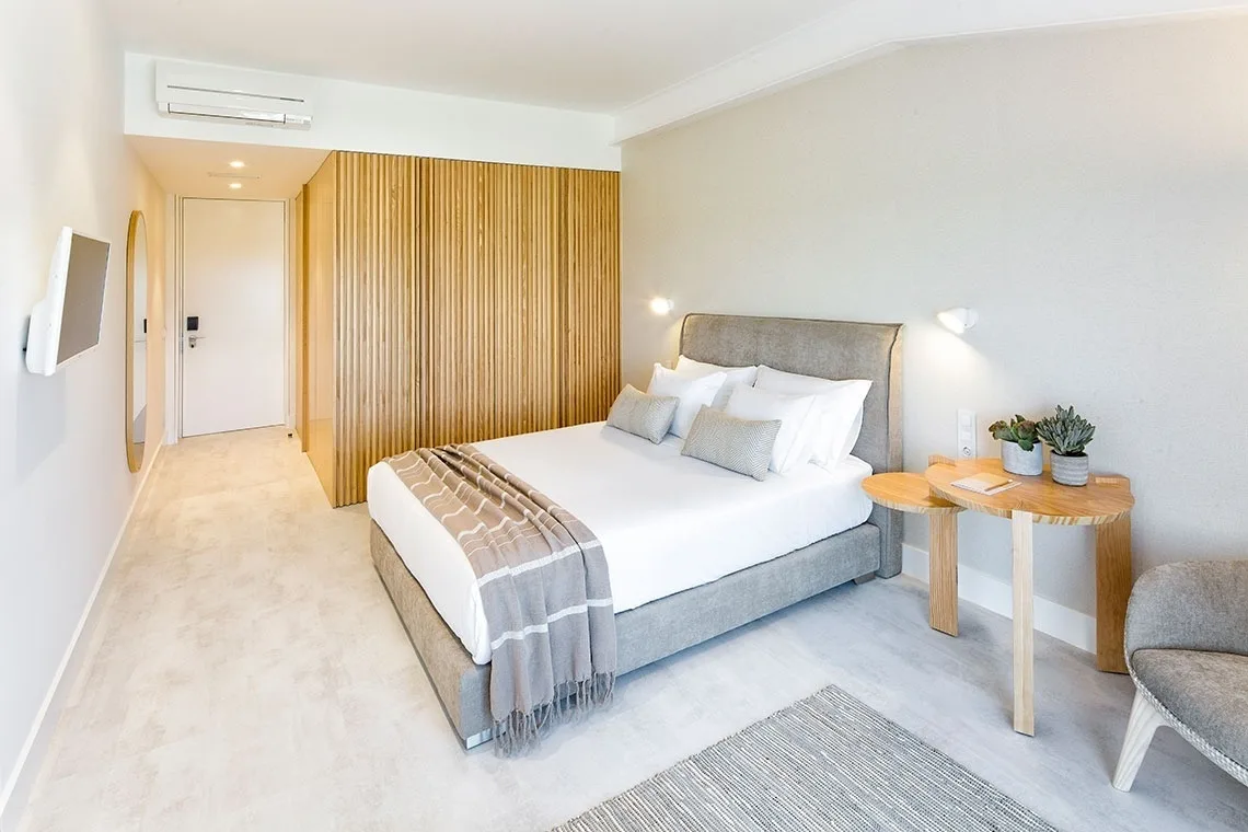Guest room with a canopy bed, artwork and wood details.