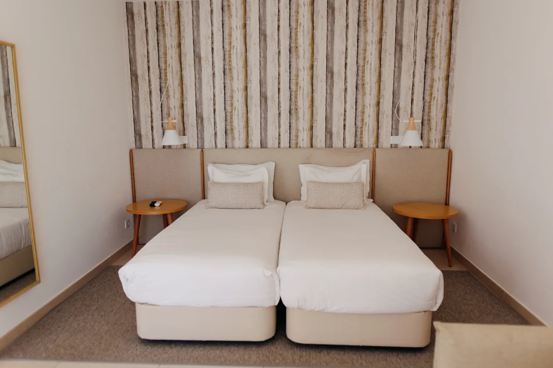 Double room with wood-effect wall covering and yellow throw.