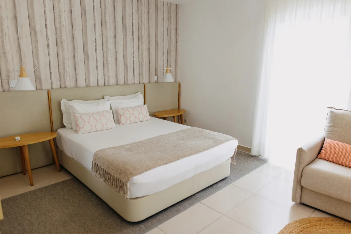 Double room with wood-effect wall covering and yellow throw.