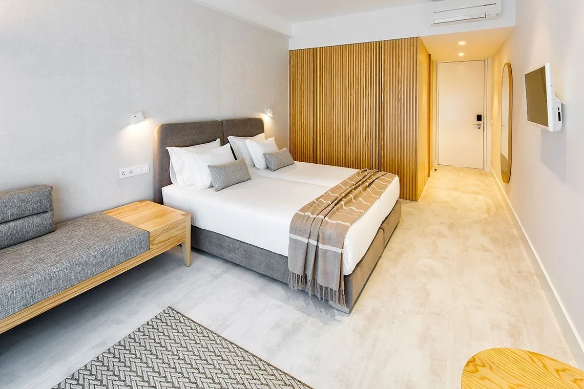 Guest room with a canopy bed, artwork and wood details.