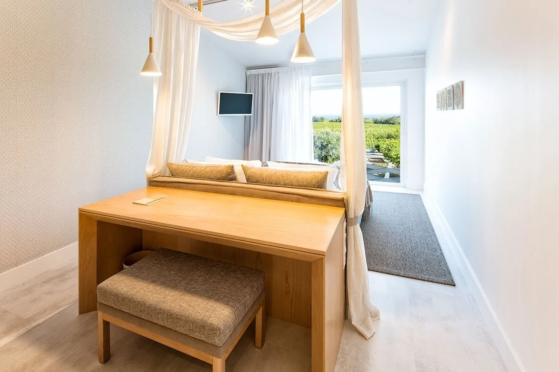 Guest room with a canopy bed, artwork and wood details.