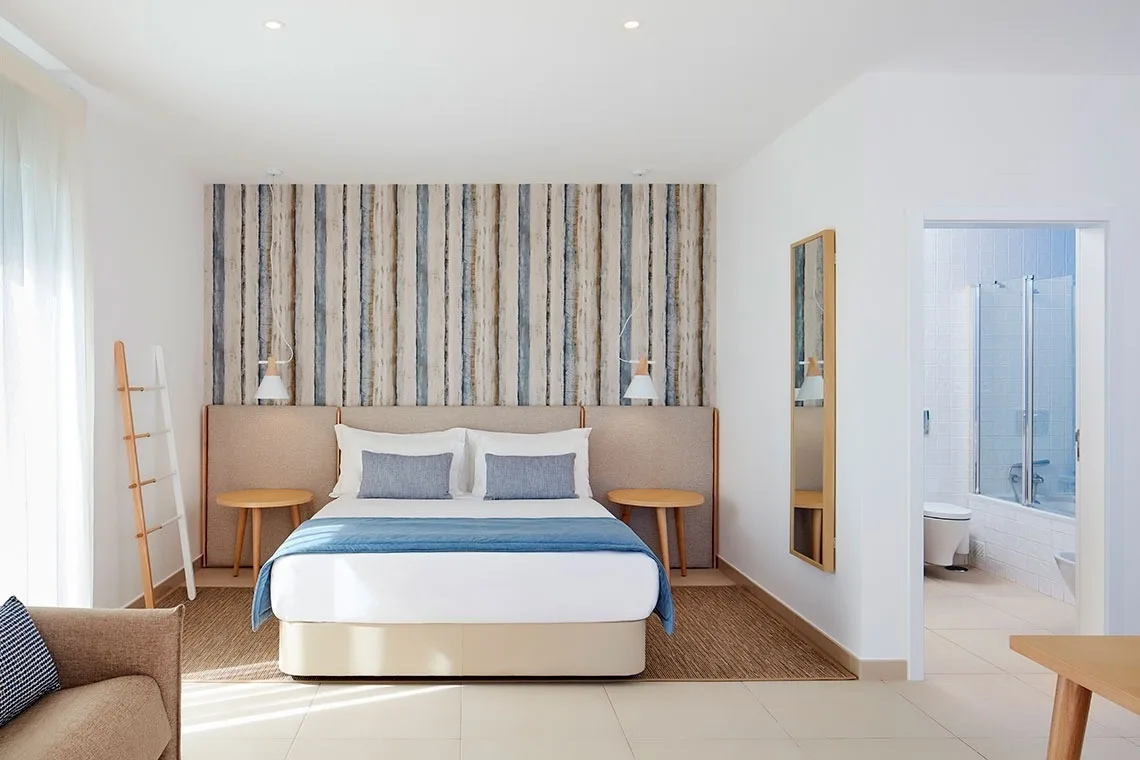 Double room with wood-effect wall covering and yellow throw.