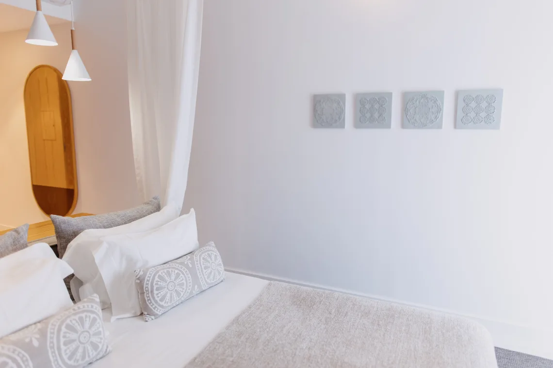 Guest room with a canopy bed, artwork and wood details.