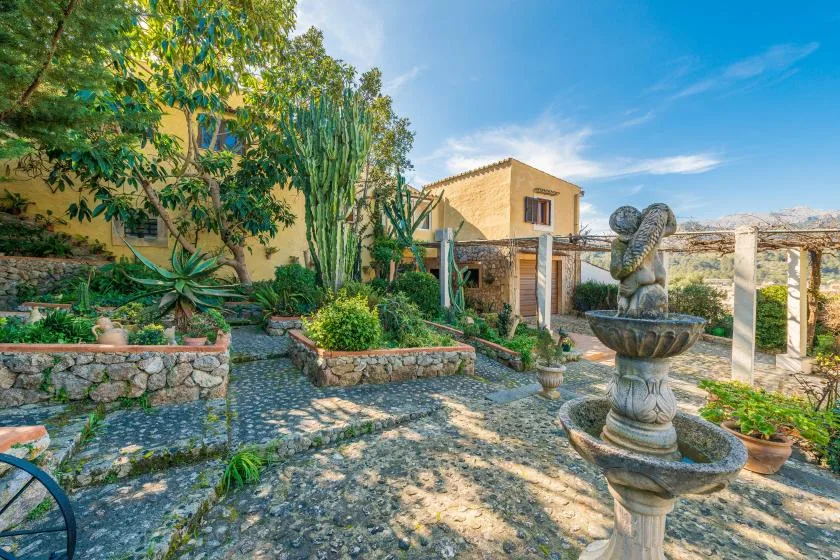 A landscaped courtyard with stone paths, raised garden beds, and a fountain.