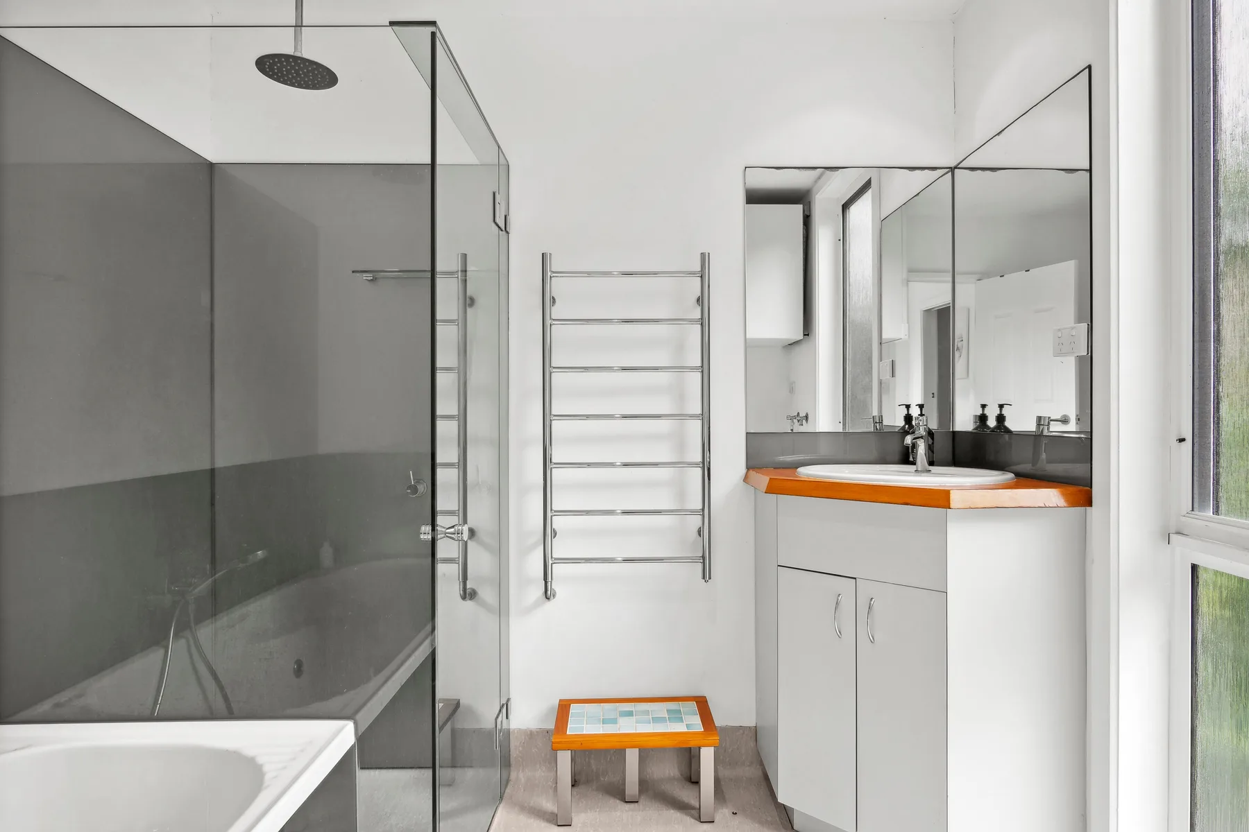 Un baño moderno con ducha de vidrio y tocador.