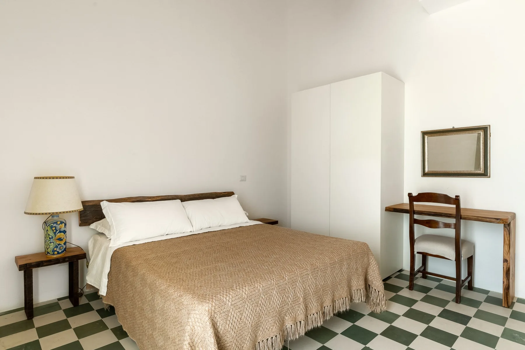 Un dormitorio con una cama, un armario y un escritorio.