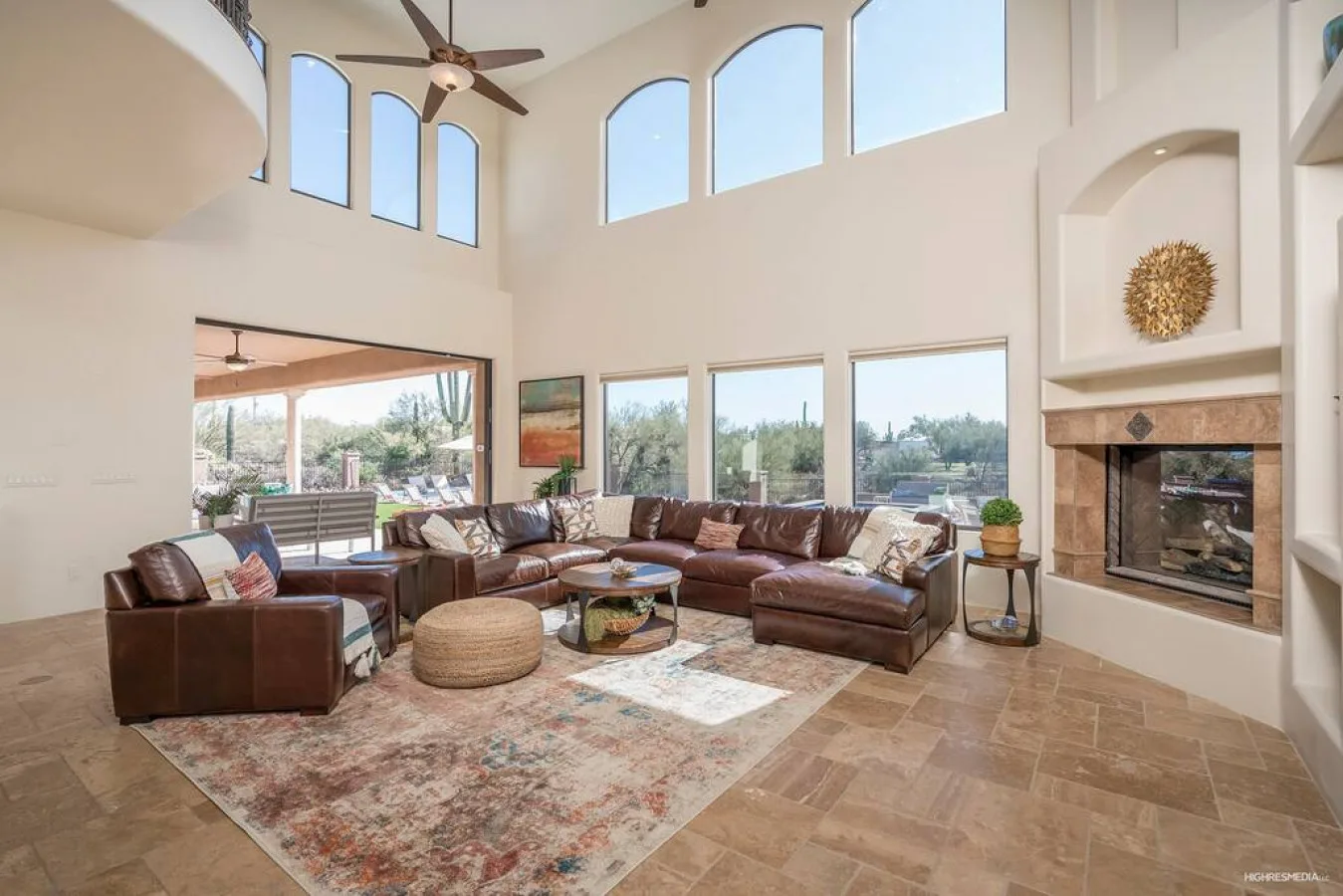 A spacious living room with sectional seating, a rug, and a fireplace.