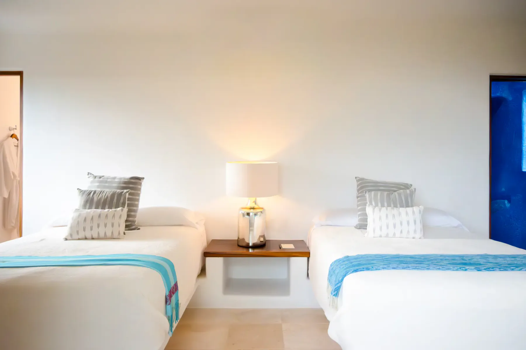 Un dormitorio con dos camas bien hechas y una mesa pequeña entre ellas.