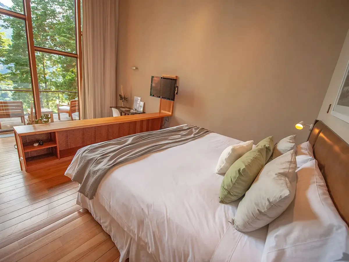 Premium Suite bedroom with forest views from the balcony