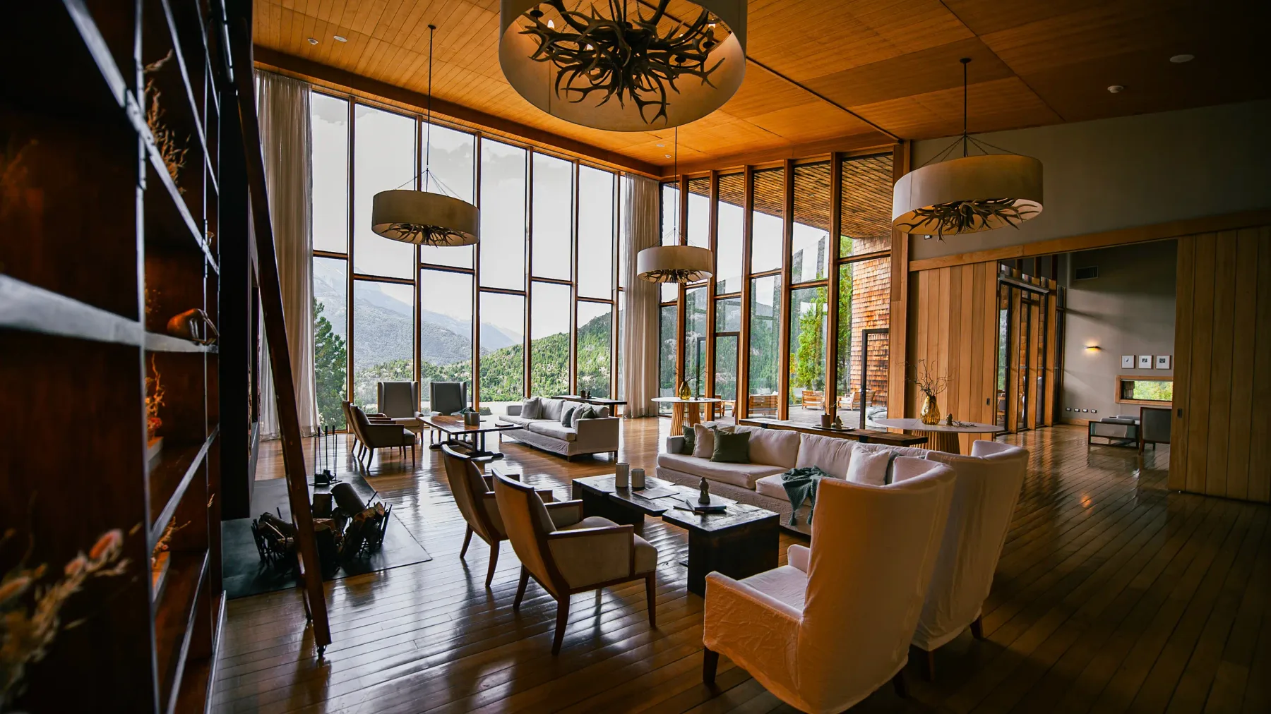 Lodge living room with floor-to-ceiling windows and mountain views