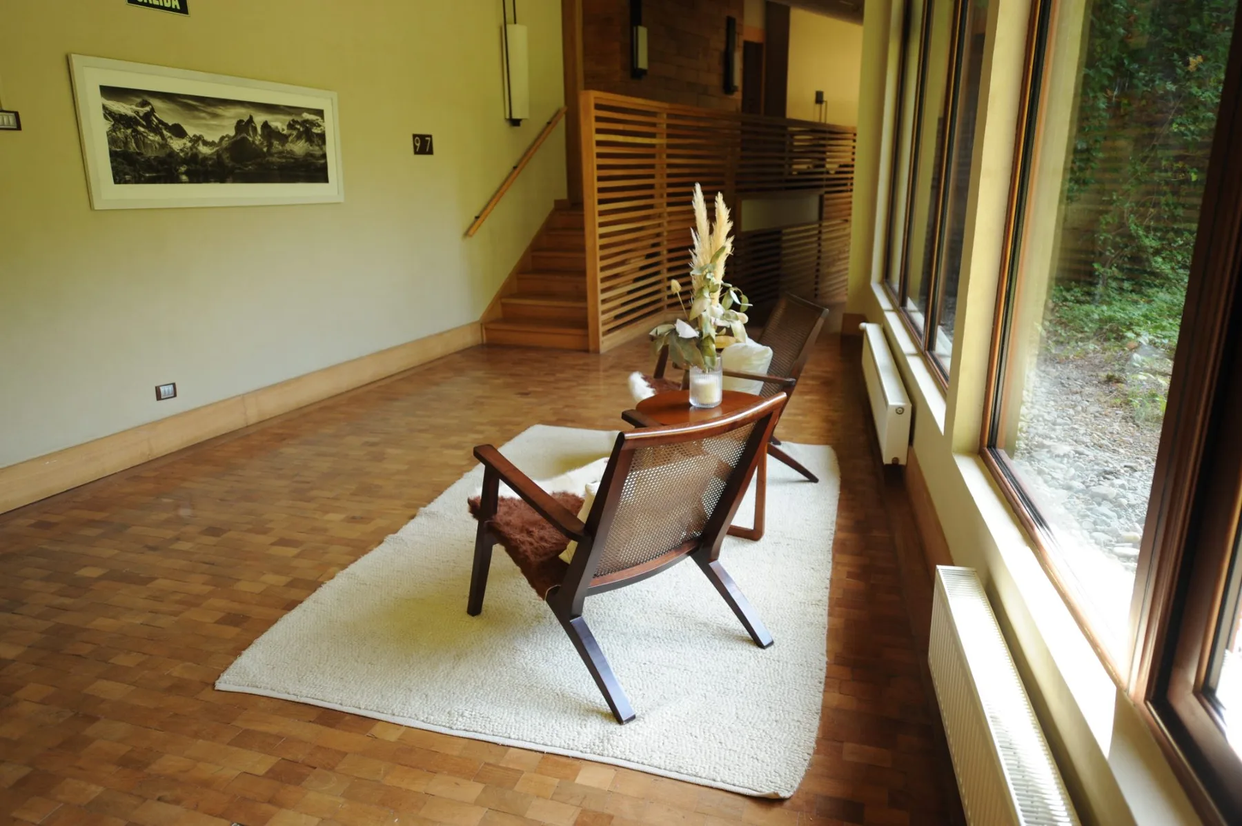 Seating in the suite access corridor beside a window overlooking the forest