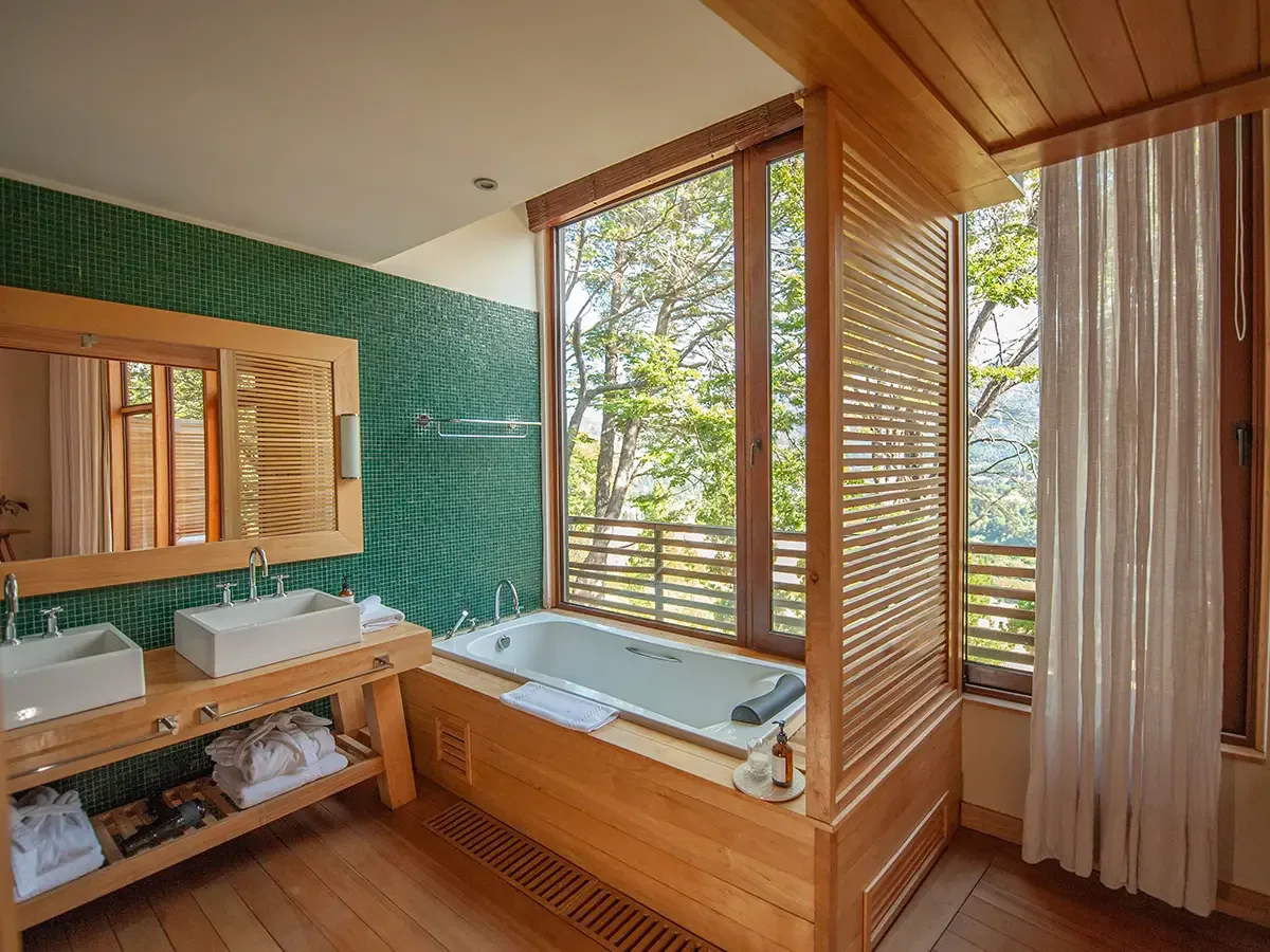 Premium Suite bathroom with bathtub and forest-facing window