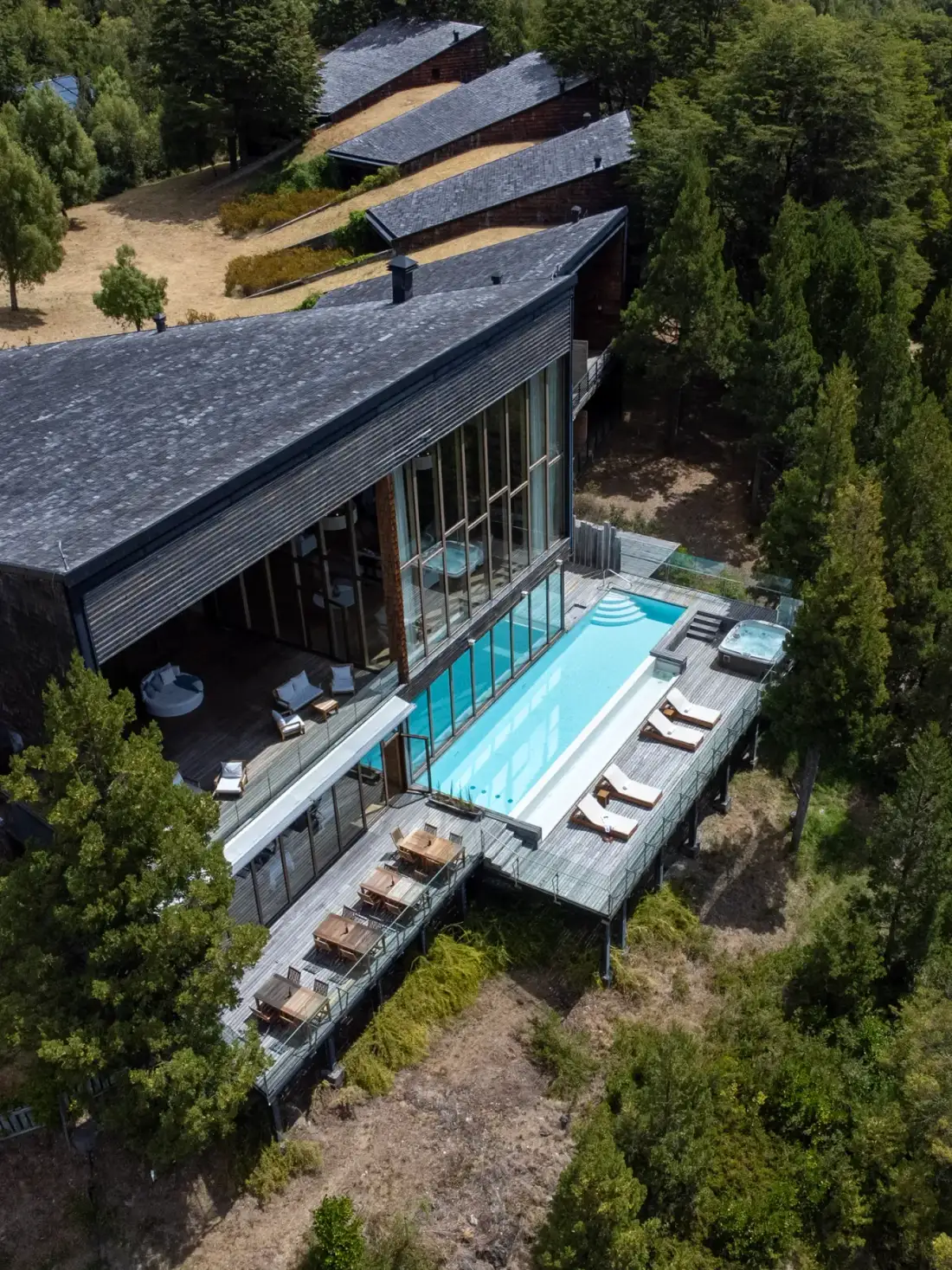 Vista aérea del lodge, la piscina al aire libre y las suites entre los árboles