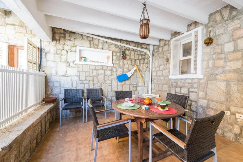 Comedor con paredes de piedra, una mesa y asientos alrededor.