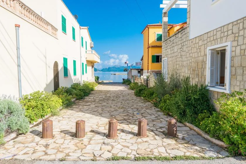 Un callejón empedrado entre edificios conduce hacia el mar.