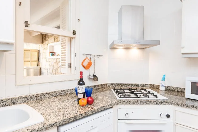 Una cocina luminosa con encimera de granito y placa de cocina integrada.