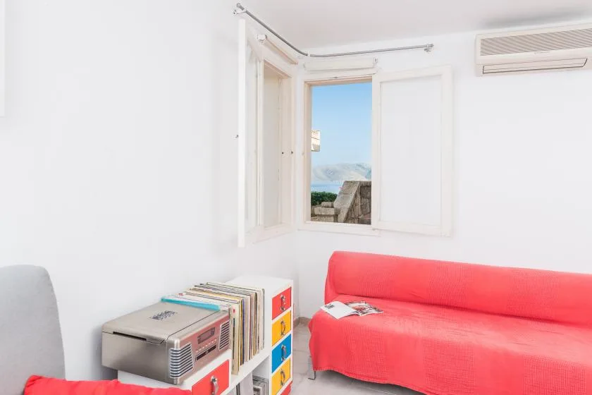 Una sala luminosa con asientos rojos junto a una ventana abierta.