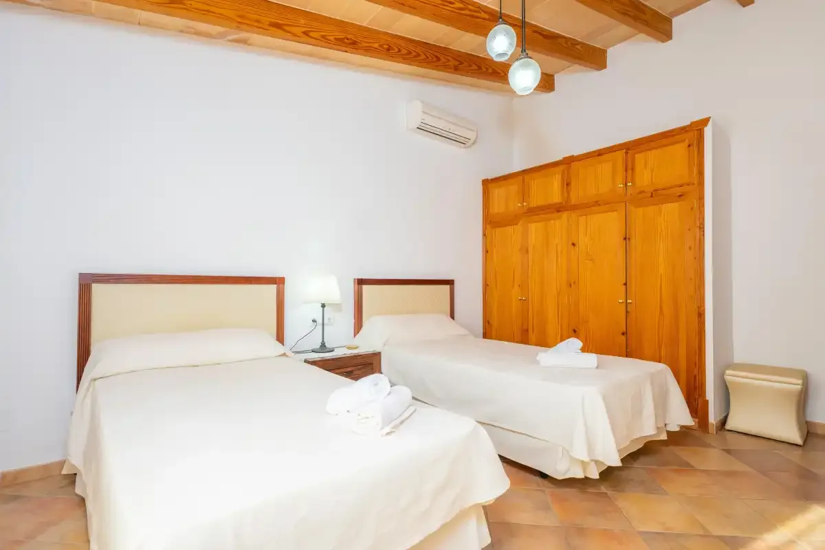 Un dormitorio con dos camas y un armario de madera.