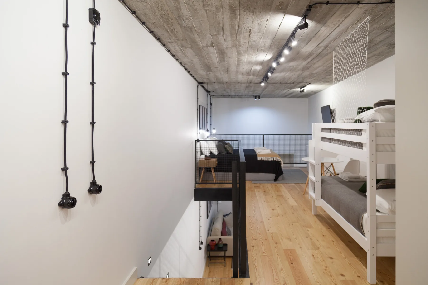 Un dormitorio tipo loft con plataformas elevadas para dormir y suelo de madera.