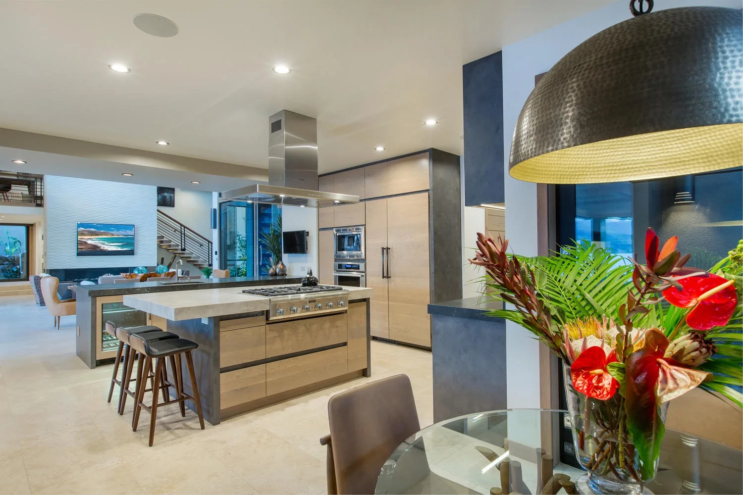 Una cocina y comedor de planta abierta cuenta con una isla y un colorido arreglo floral.