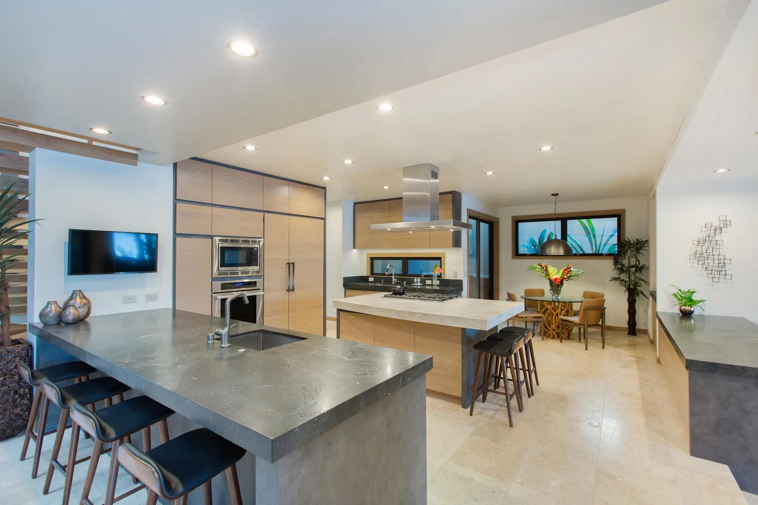 A modern kitchen with a large island and a dining area beyond.