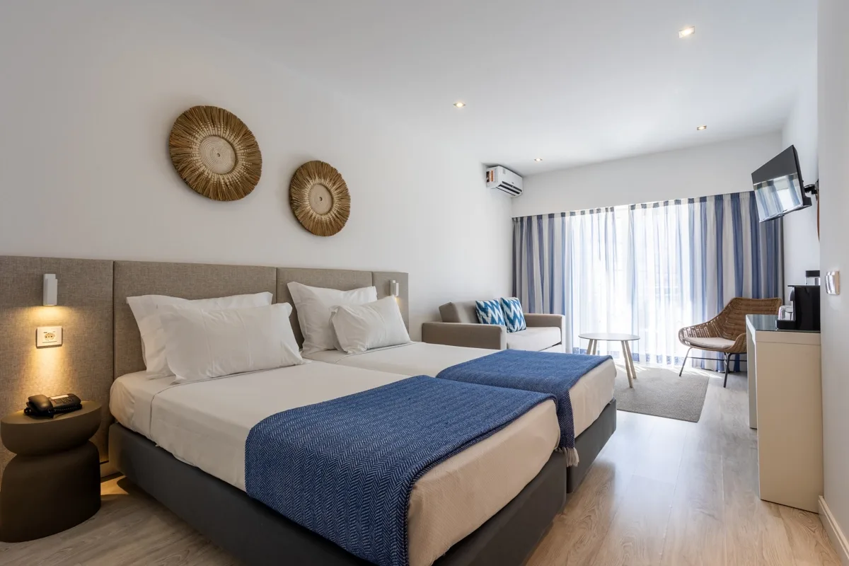 Hotel room with a bed, sofa, table and television