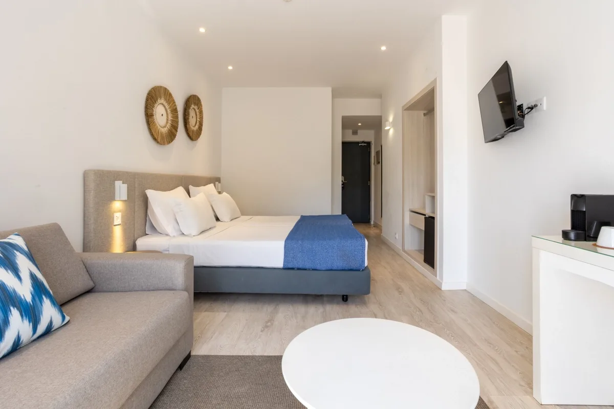 Hotel room with a bed, sofa, table and television