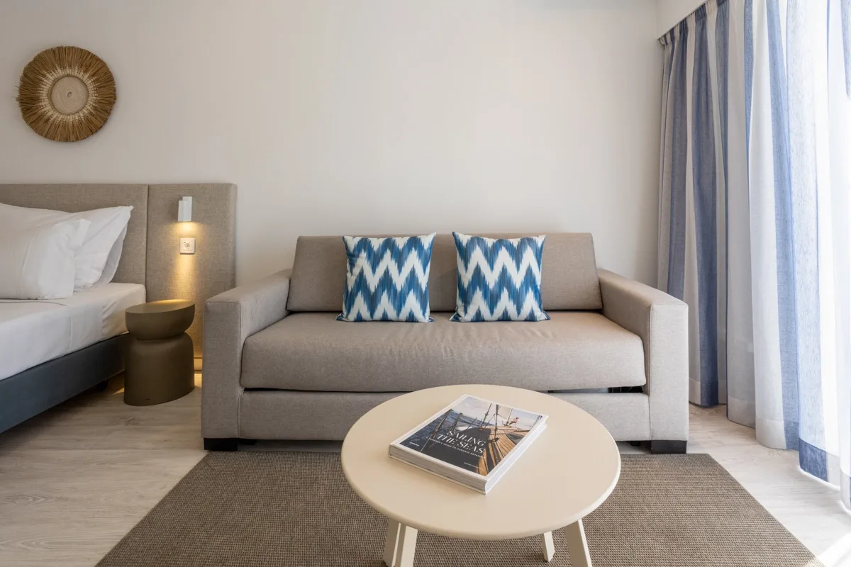 Hotel room with a bed, sofa, table and television