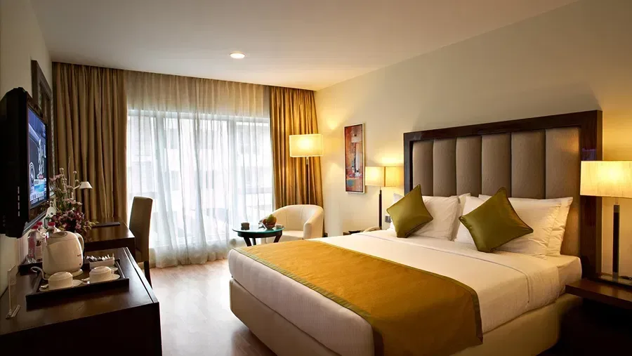 Executive King room with a double bed, television, cabinet, sofa, and centre table.