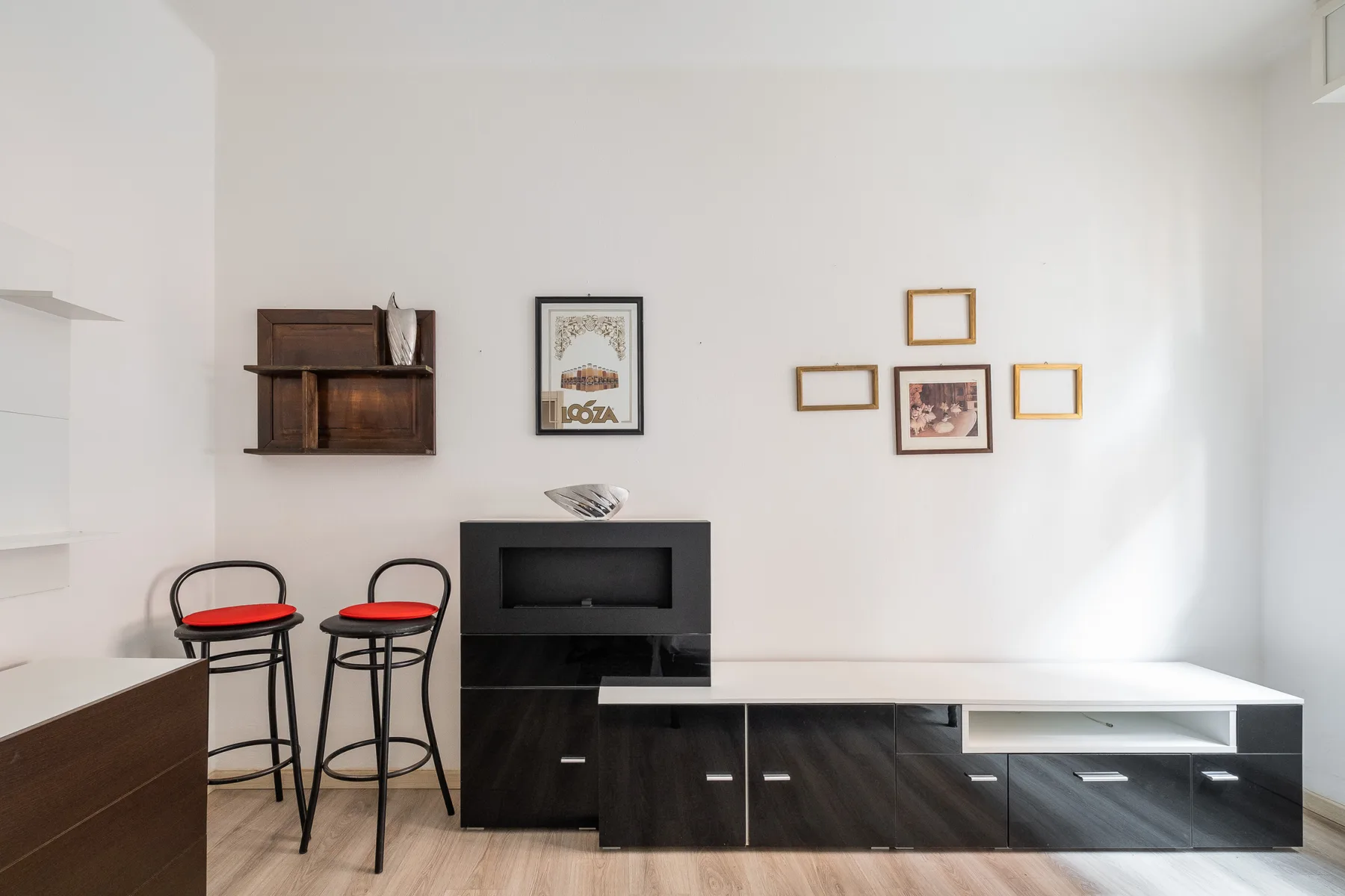 A living room with dark cabinets, a low table, and wall art.