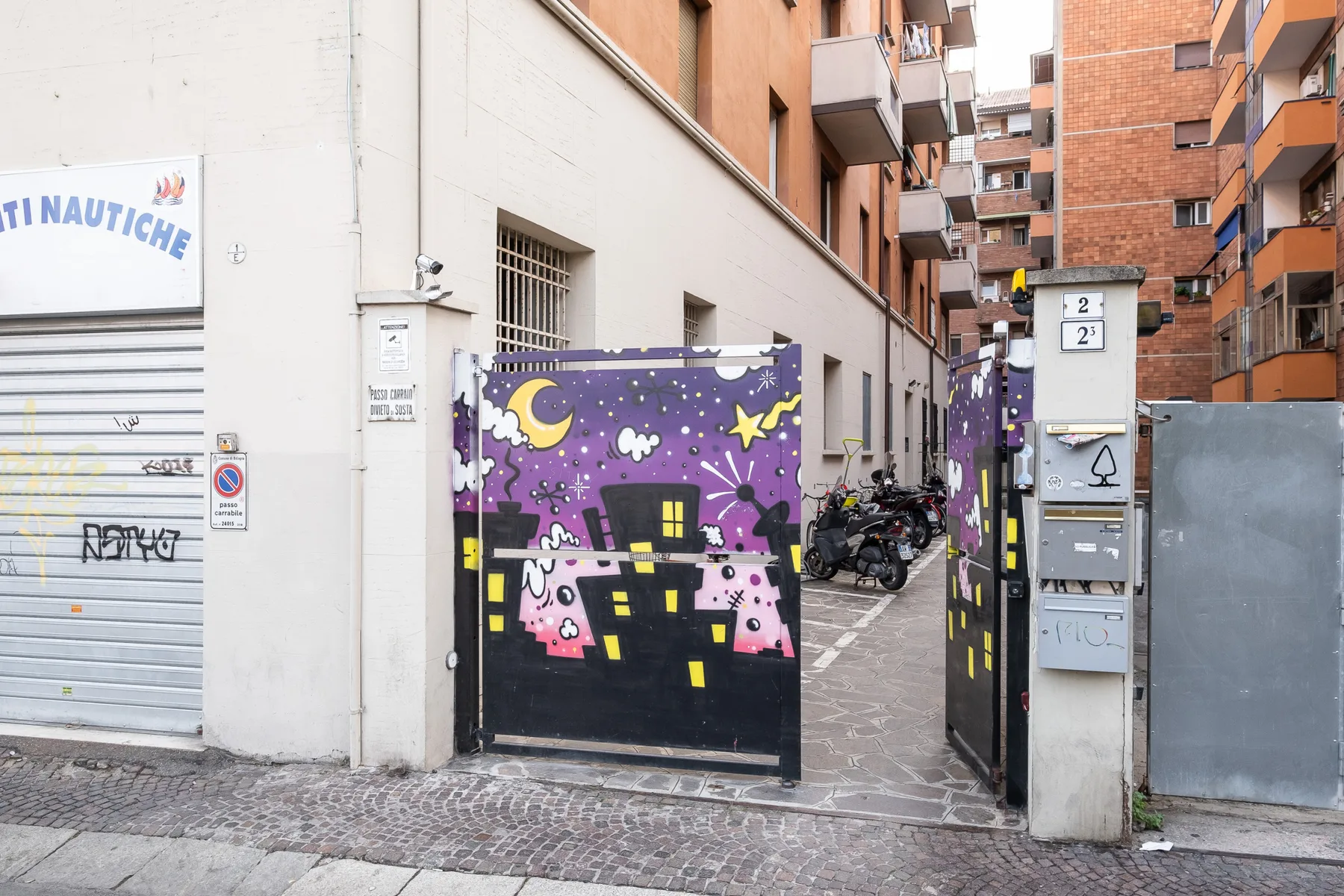 An apartment building entrance with purple gates painted with colorful nighttime scenes.