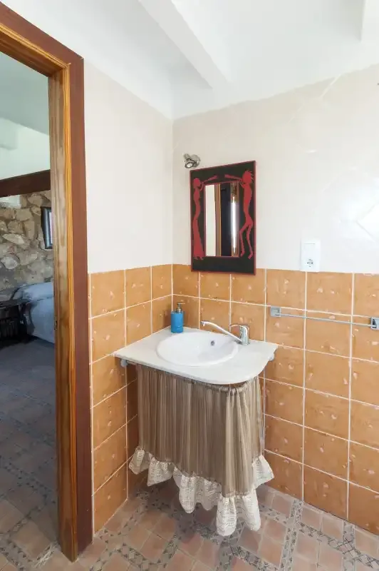 A bathroom with a white sink and a mirror above it.