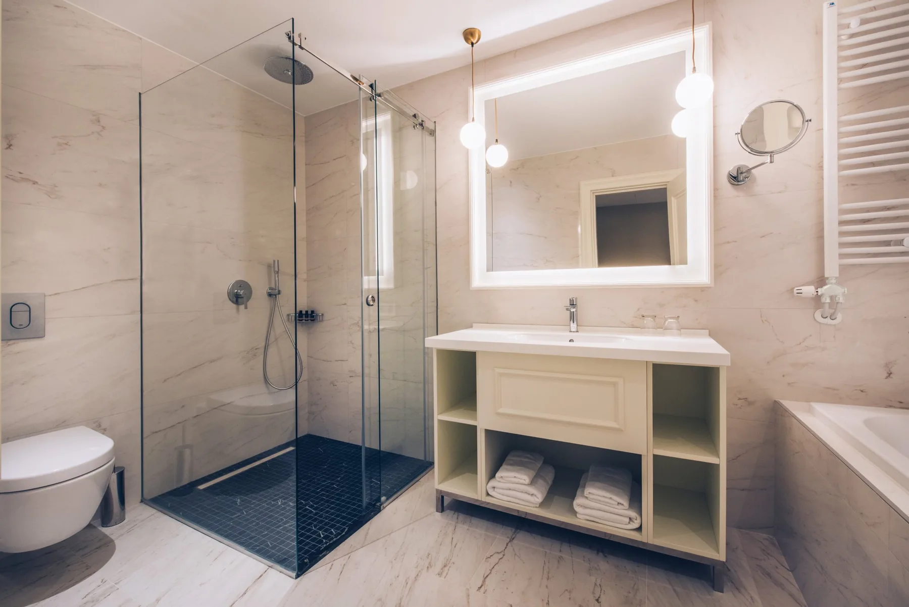 Hotel bathroom with shower, sink area and mirror