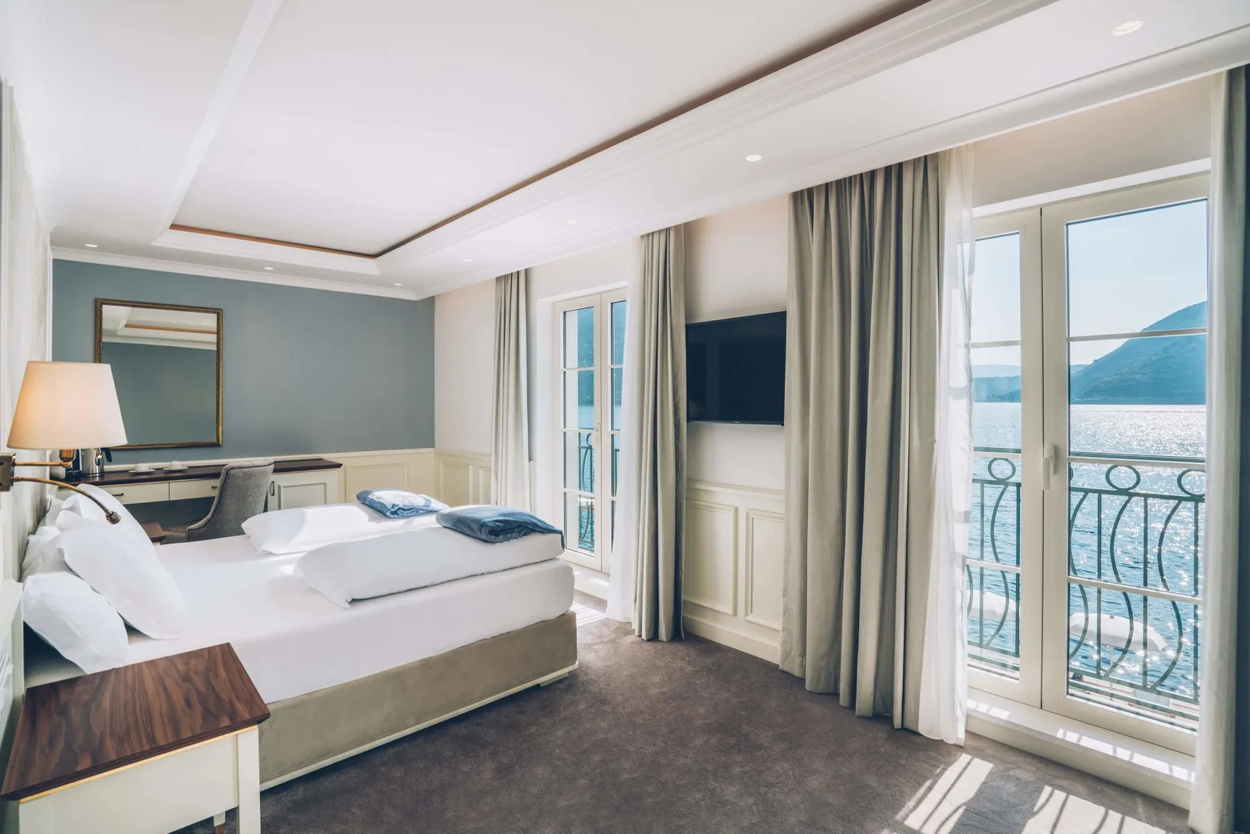Hotel room with tall windows overlooking the sea