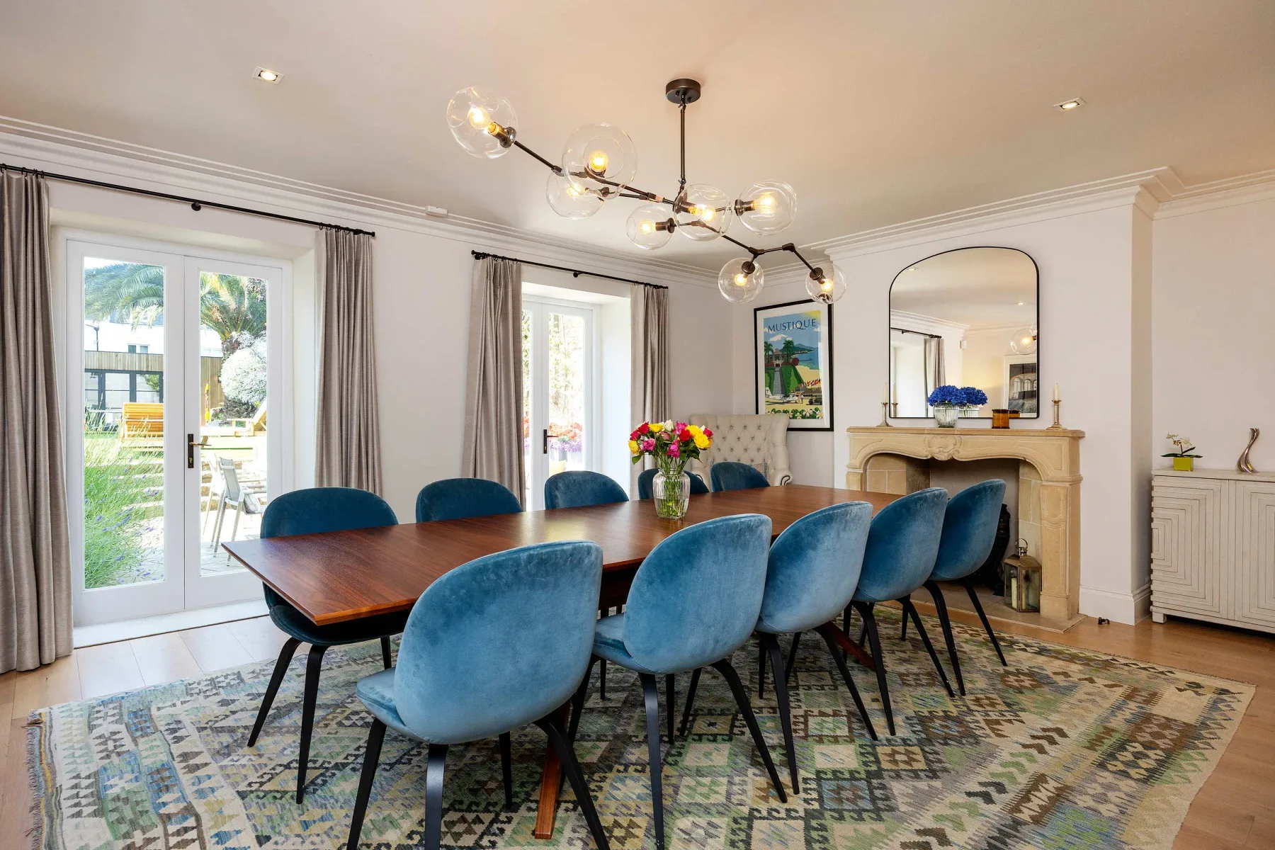 Un comedor con asientos azules alrededor de una mesa de madera y una chimenea.