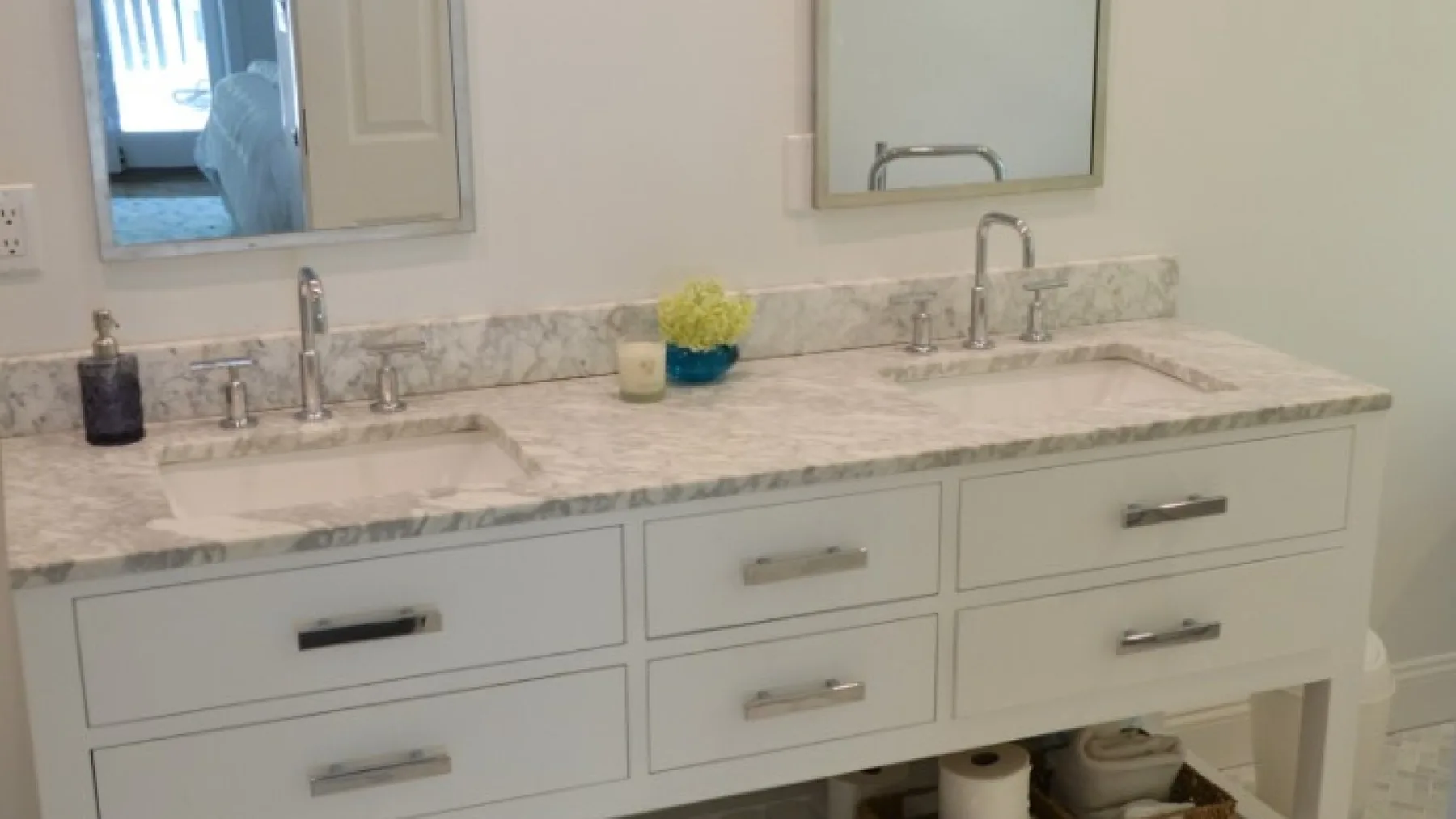 Un tocador de baño con una encimera larga, dos lavabos y espejos encima.