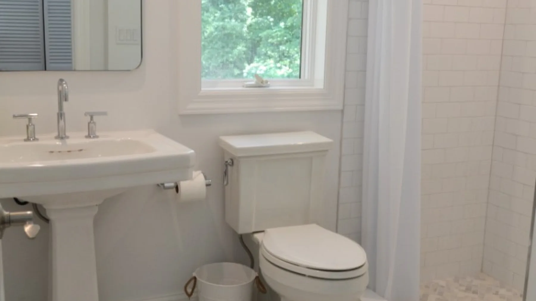 Un baño con lavabo, inodoro y ducha con cortina.