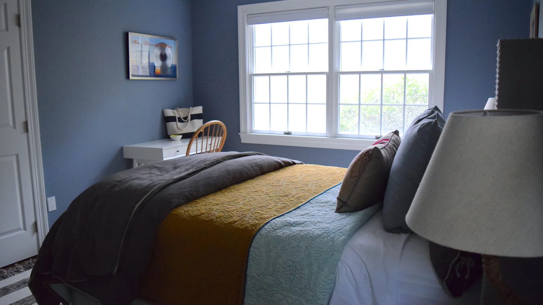 Un dormitorio con una cama junto a una ventana luminosa.