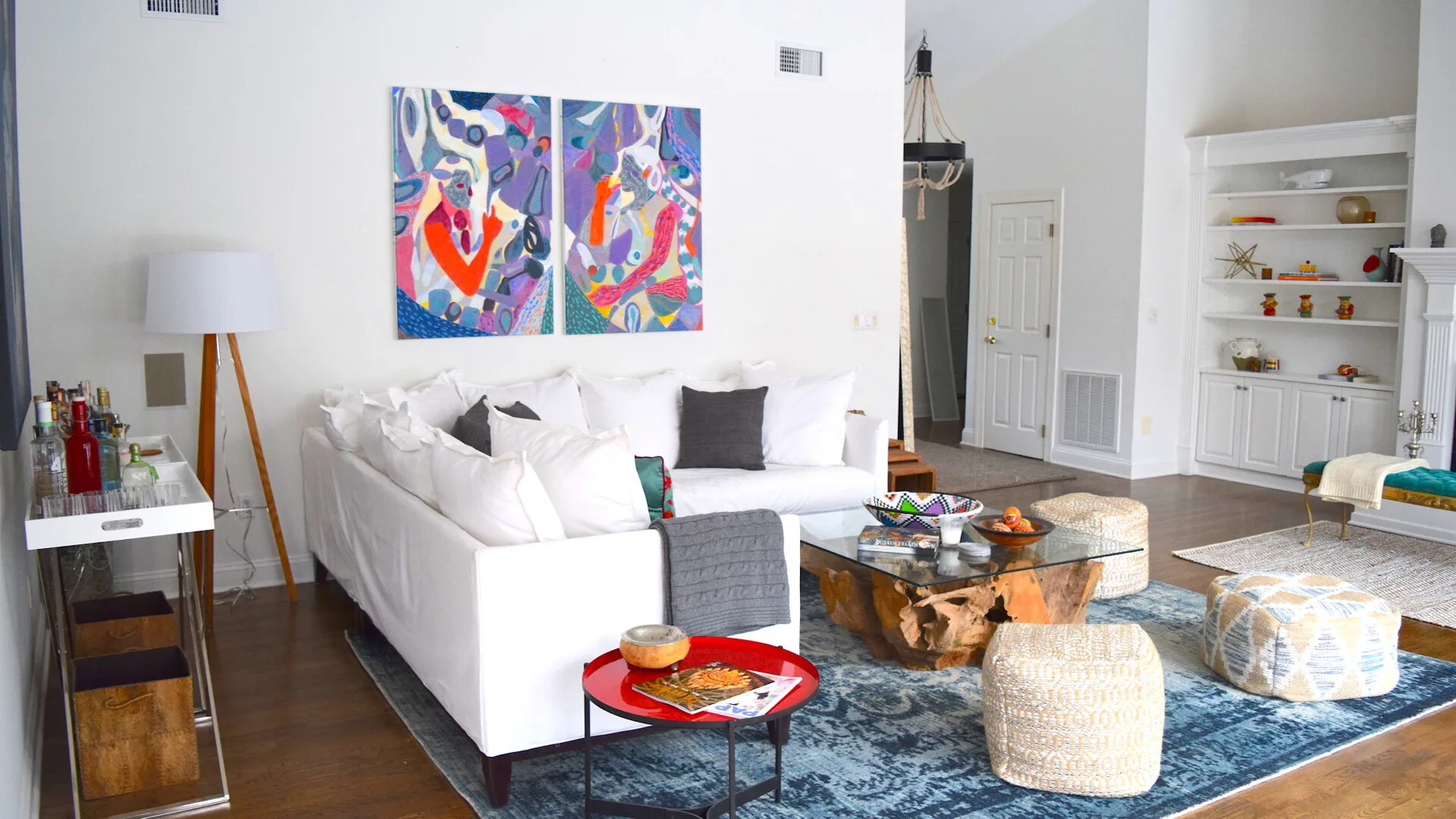 Una sala luminosa con asientos blancos, arte colorido en la pared y una alfombra estampada.