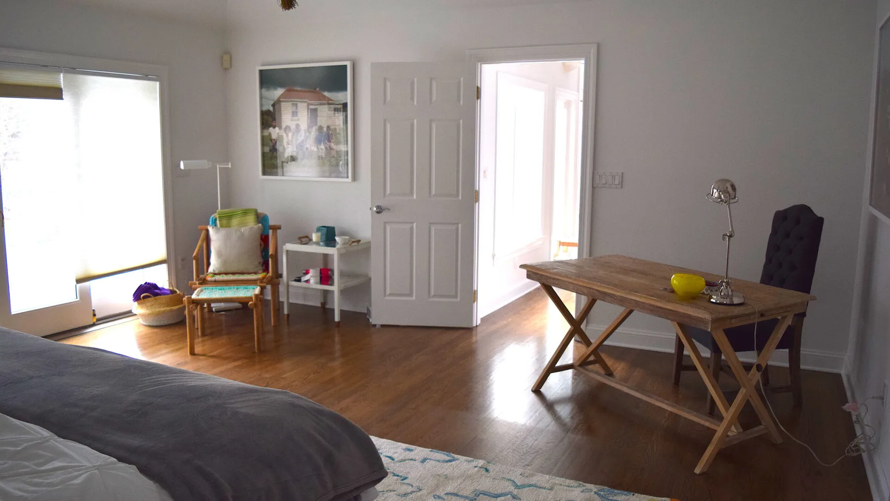 Un dormitorio con una mesa de madera y asientos junto a una puerta abierta.