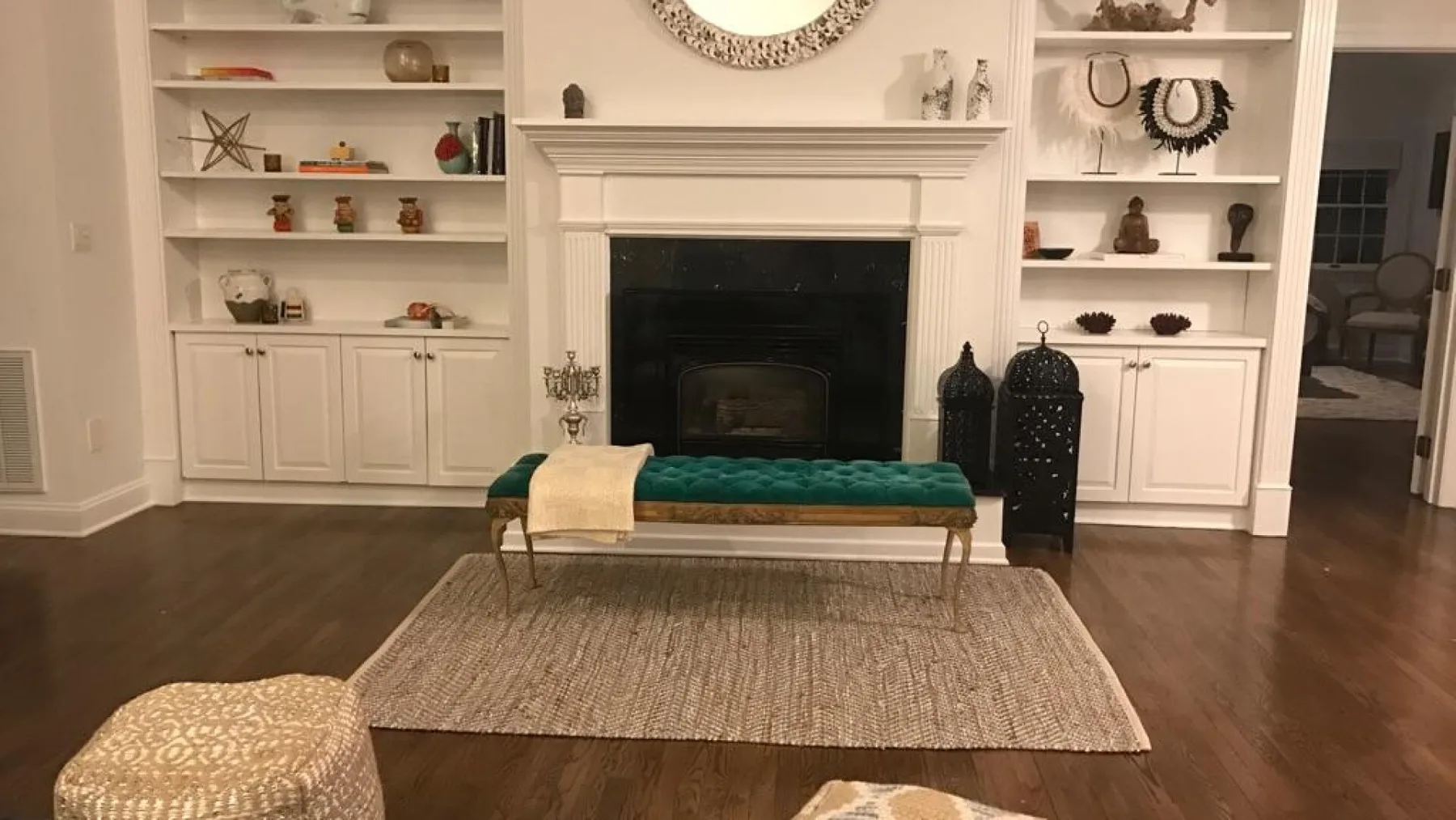 Una sala de estar con chimenea, estanterías empotradas y una alfombra.