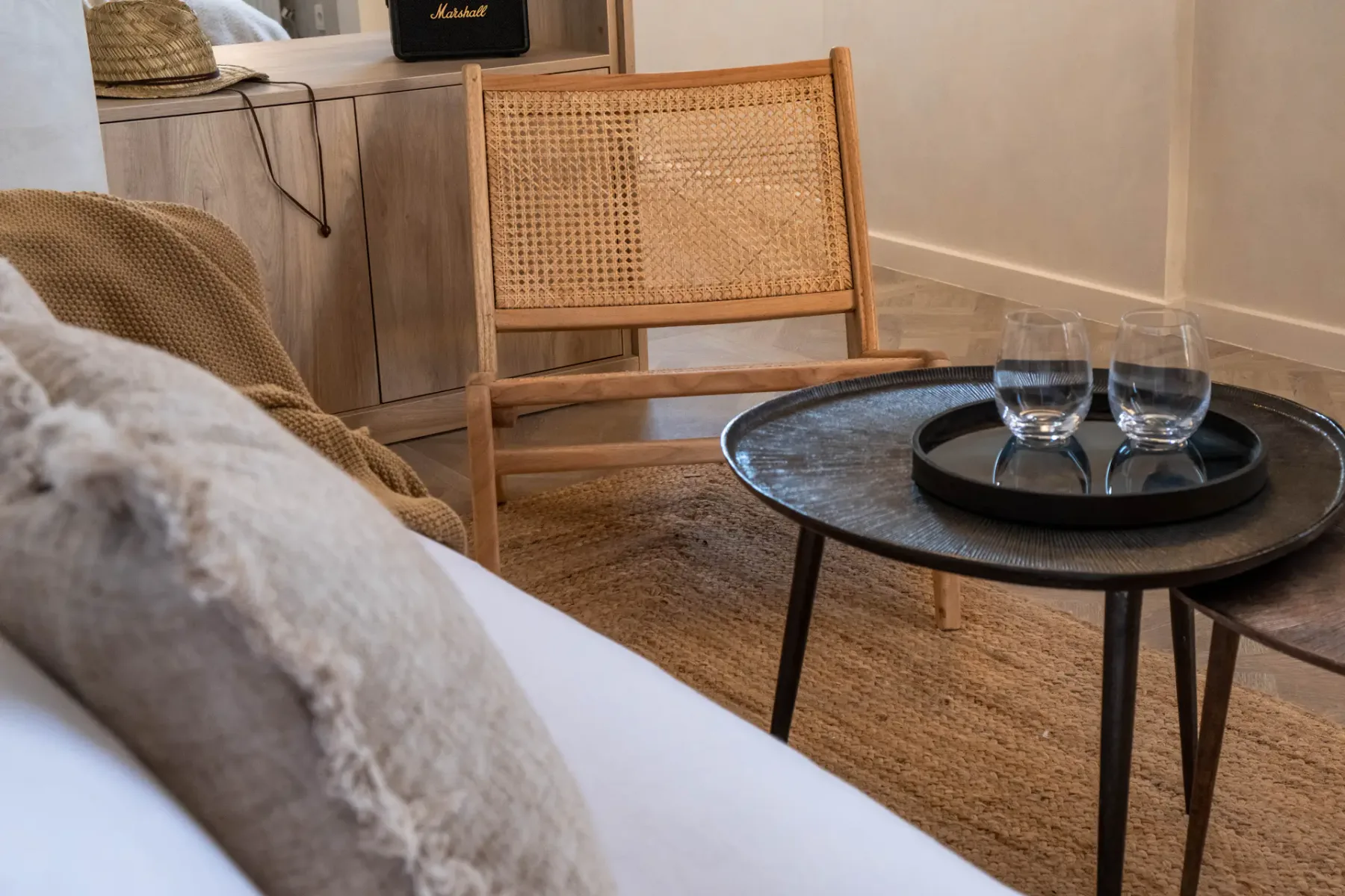 A sitting area with a woven chair and a round coffee table.