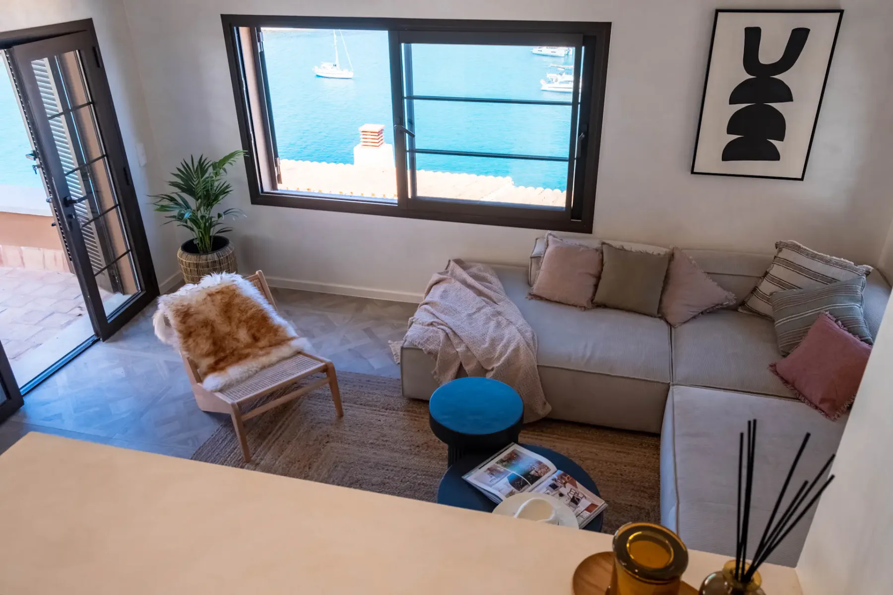 A living room with a sectional seating area and large windows overlooking the water.