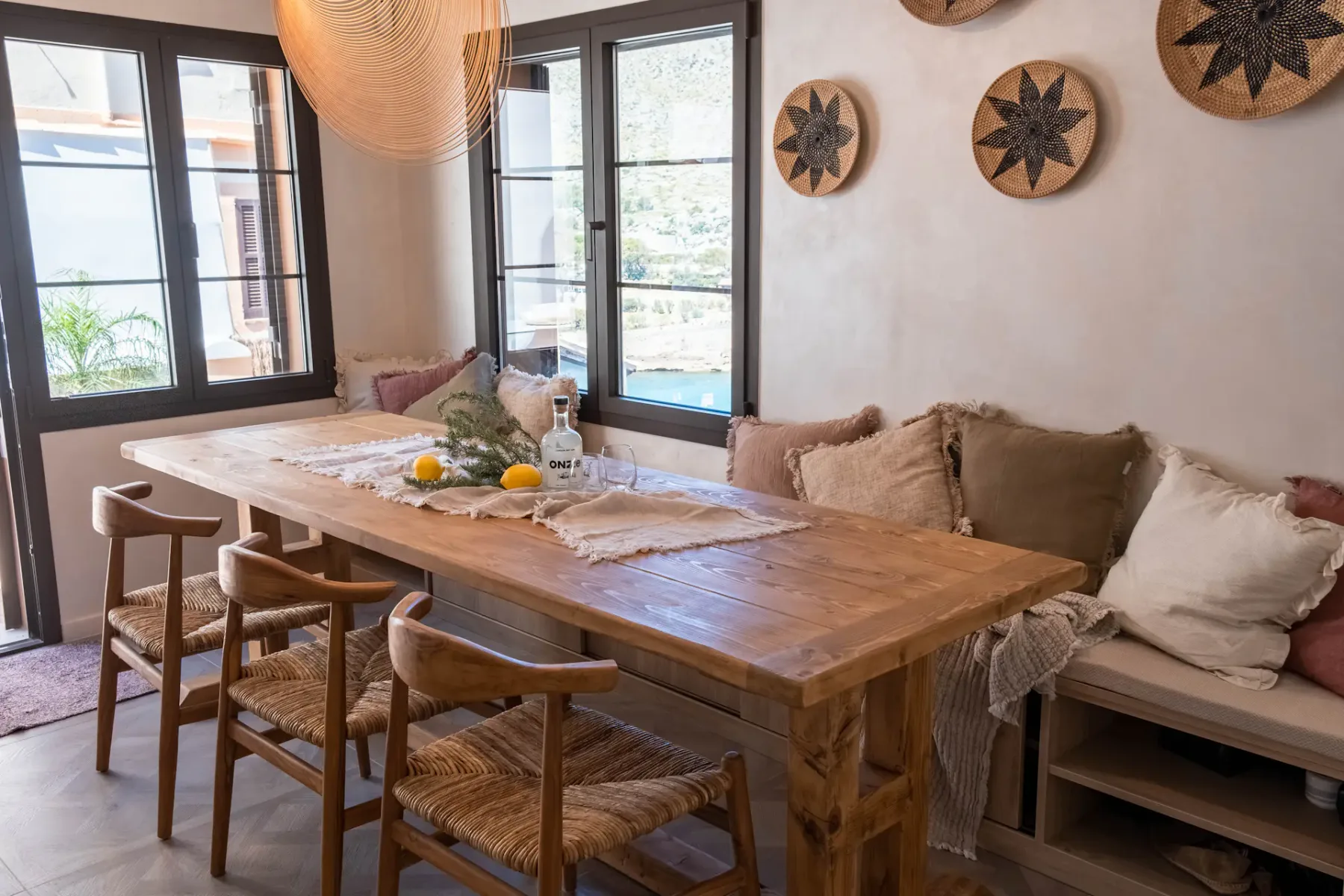 A dining area with a wooden table, chairs, and cushioned bench seating.