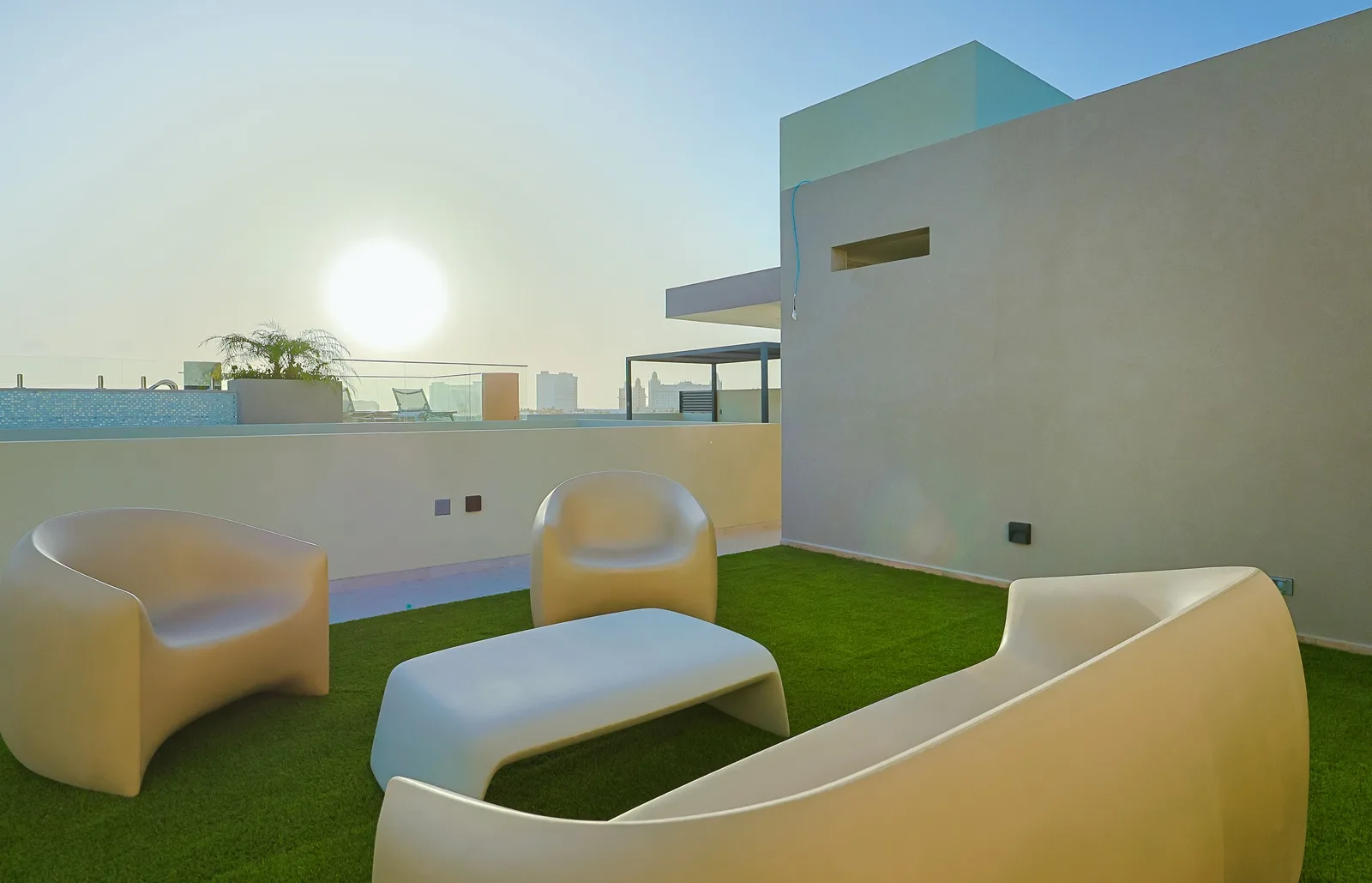 The rooftop features modern architecture with clean lines and minimalist design, blending seamlessly with the relaxed charm of the surrounding area.