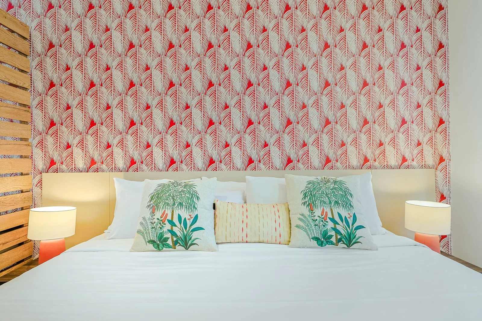 Rest comfortably in the inviting king-size bed, where crisp white linens, tropical accent pillows, a striking botanical feature wall, and soft lighting create a peaceful space to relax and recharge.