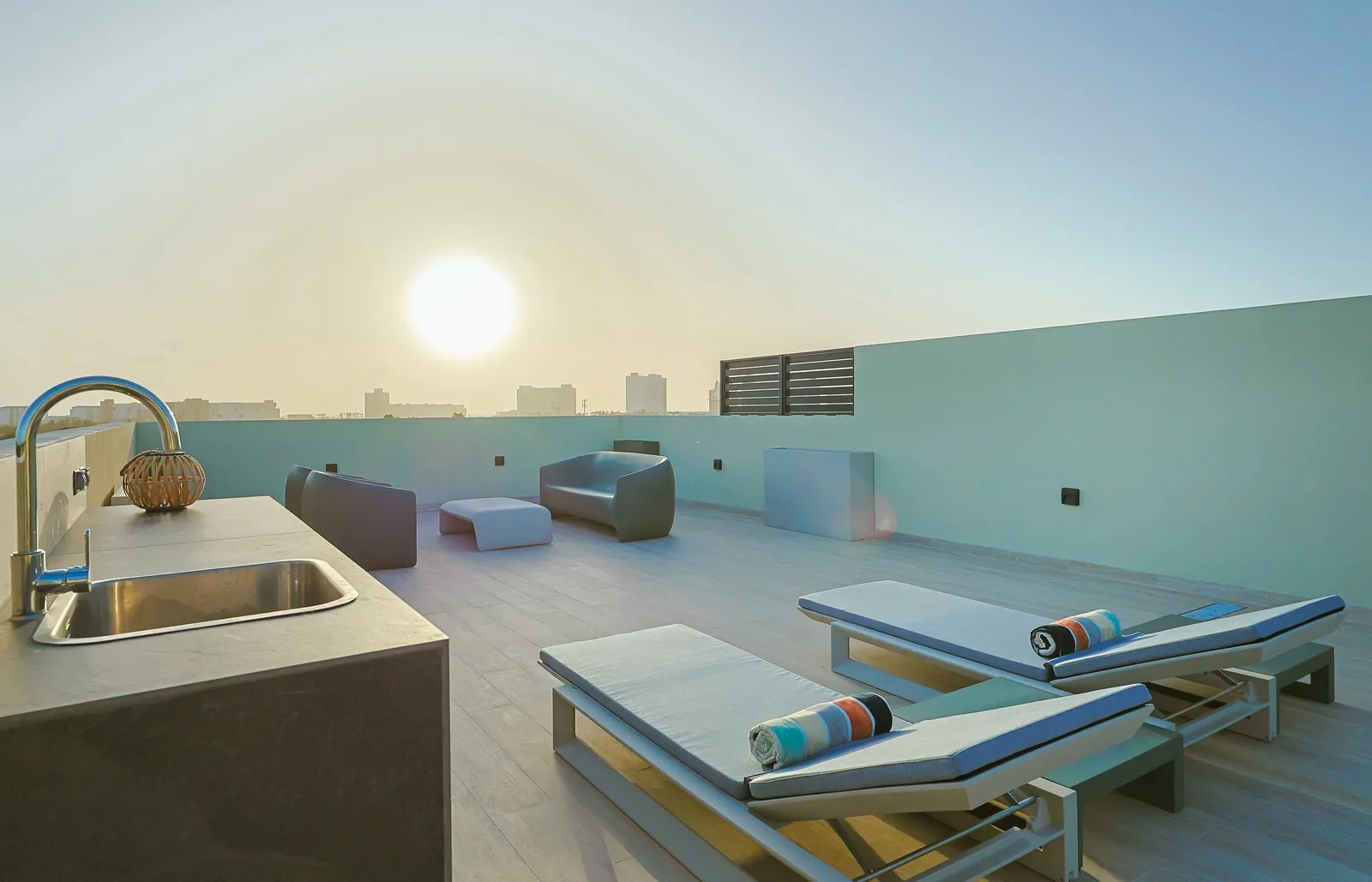 Unwind on this contemporary rooftop terrace featuring plush loungers and modern outdoor seating, creating a serene space to enjoy the fresh air and Aruba's beautiful sunsets.