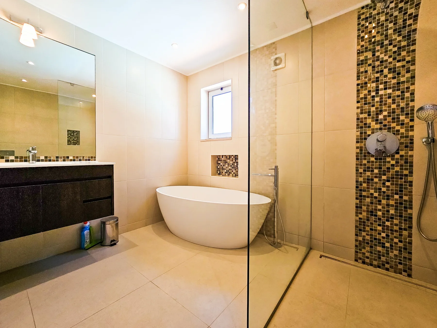 Un baño con bañera, lavabo y ducha de vidrio.
