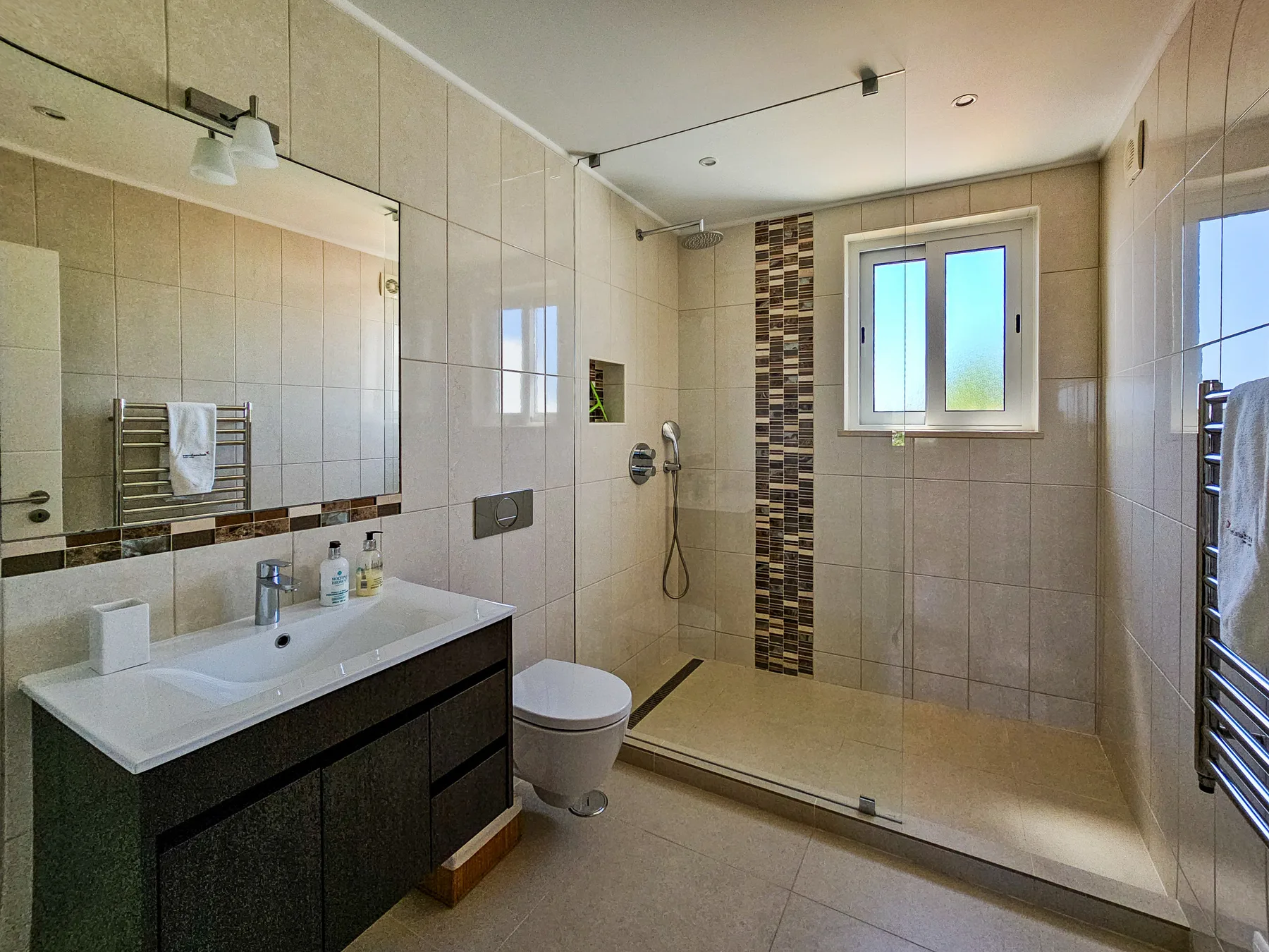 Un baño alicatado con lavabo, inodoro y ducha.